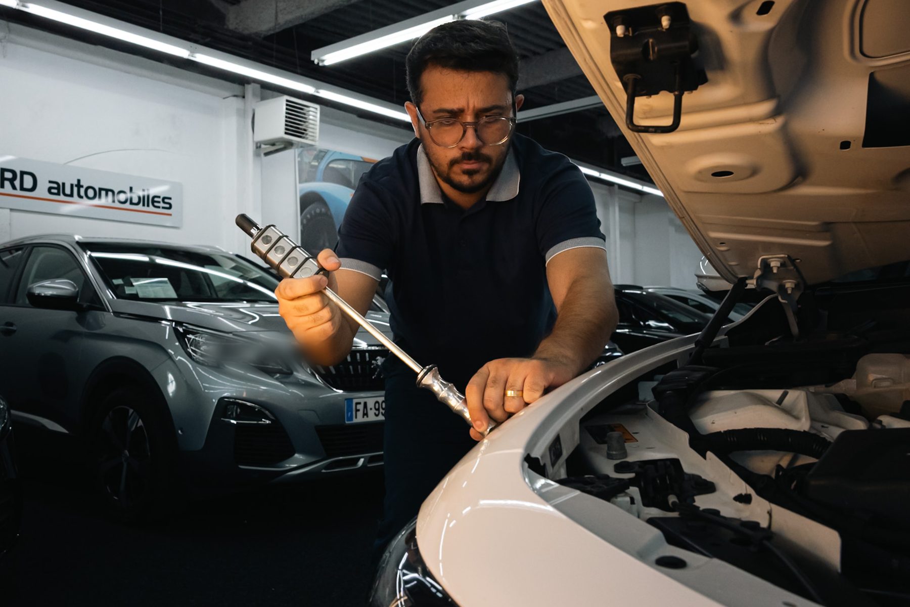 Technicien Euro Storm réparant une carrosserie grêlée au débosselage sans peinture.